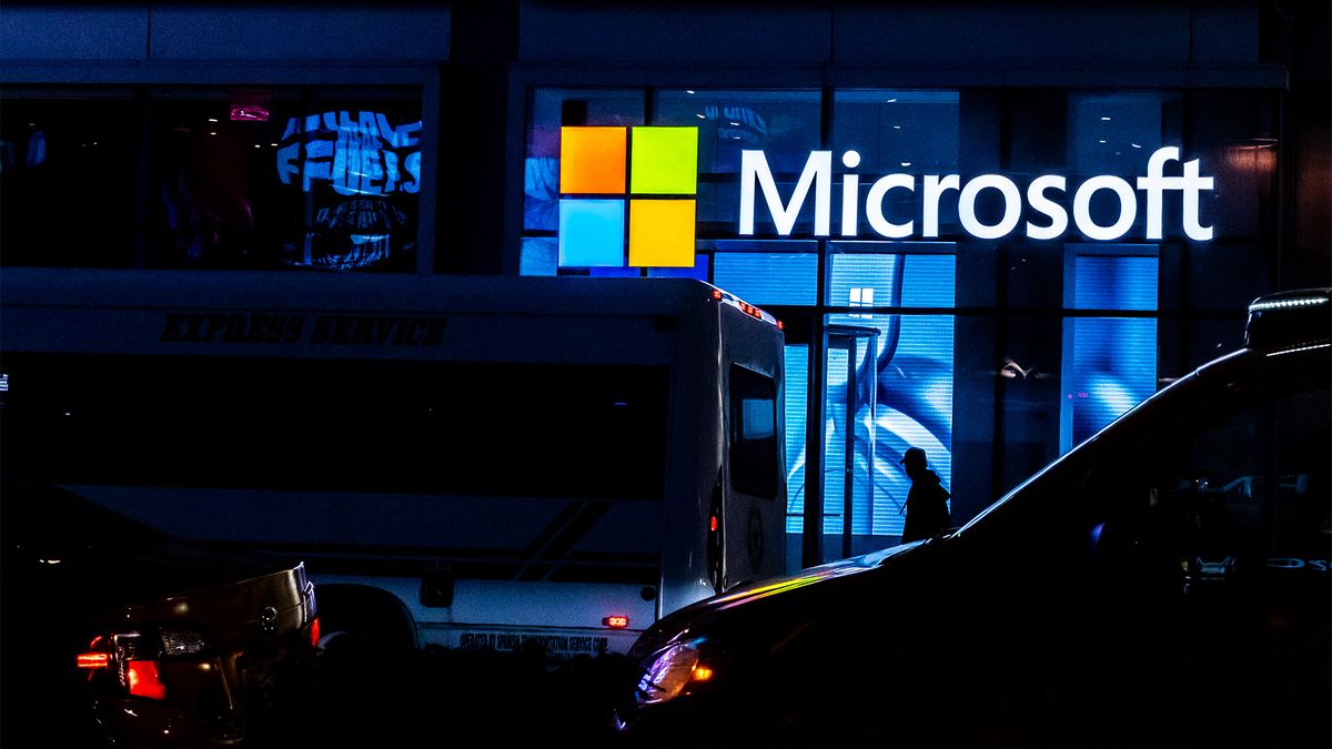 Microsoft sign featuring logo pictured at night in New York City, United States.